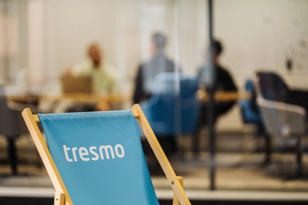 Liegestuhl mit tresmo Logo vor gläsernem Meetingraum.