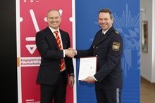 Auf dem Foto (v.l.): Prof. Dr. Gordon Thomas Rohrmair, Präsident der Hochschule Augsburg, und Michael Schwald, Präsident des Polizeipräsidiums Schwaben Nord, besiegeln die Kooperationsvereinbarung. 